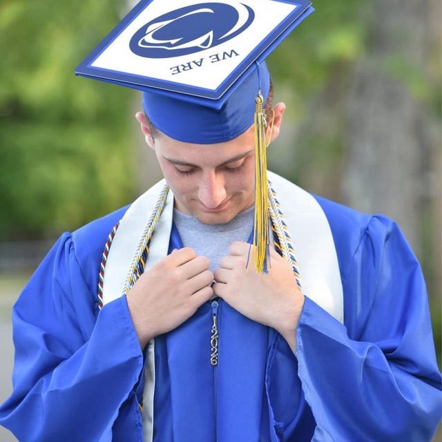 Graduate wearing a Penn State logo grad cap topper