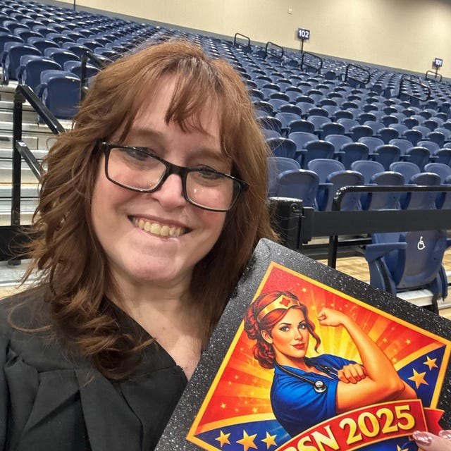 Graduate holding a Rosie the Riveter 'BSN 2025' nursing grad cap topper in an arena