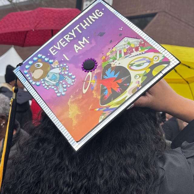 Graduate wearing a Kanye West 'Everything I Am' Graduation album grad cap topper