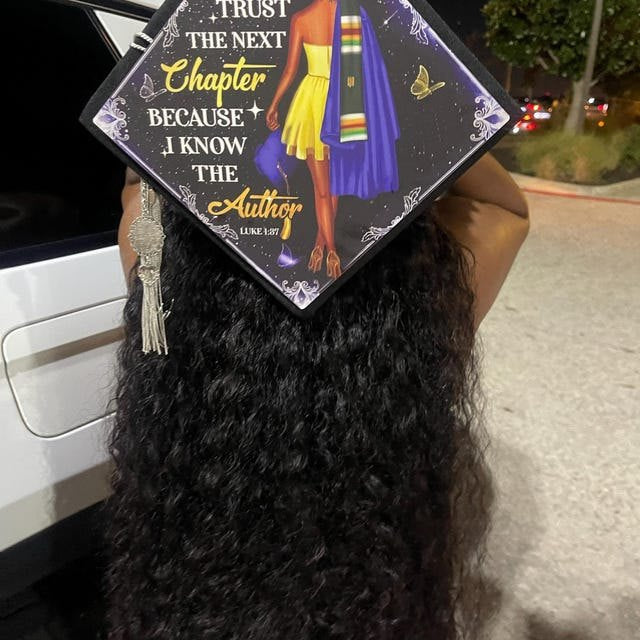 Graduate wearing an 'I Trust the Next Chapter Because I Know the Author' grad cap topper at night