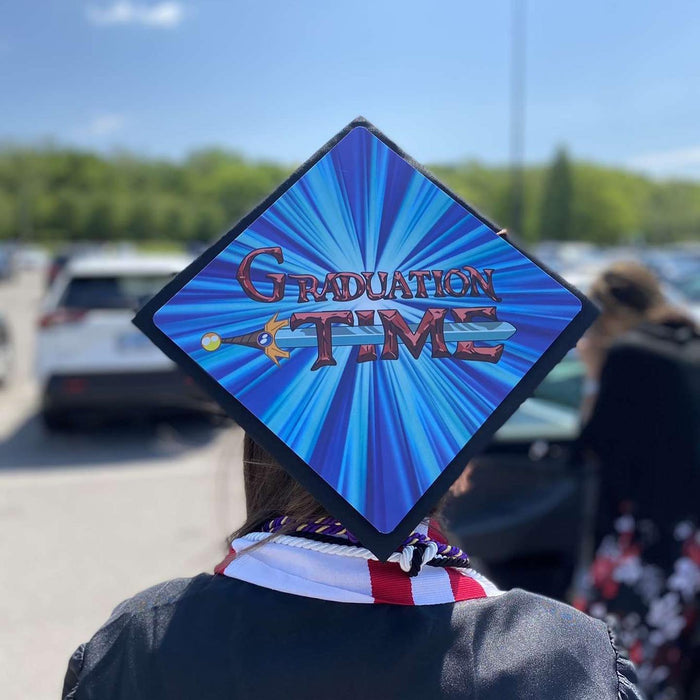 Graduate wearing an Adventure Time 'Graduation Time' grad cap topper