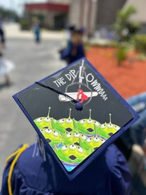 Graduate wearing Toy Story aliens THE DIPLOWMA cap, back view