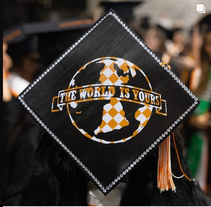 Graduate wearing The World Is Yours globe cap at ceremony