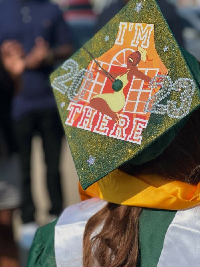 Graduate wearing Im There 2023 guitar cap, back view