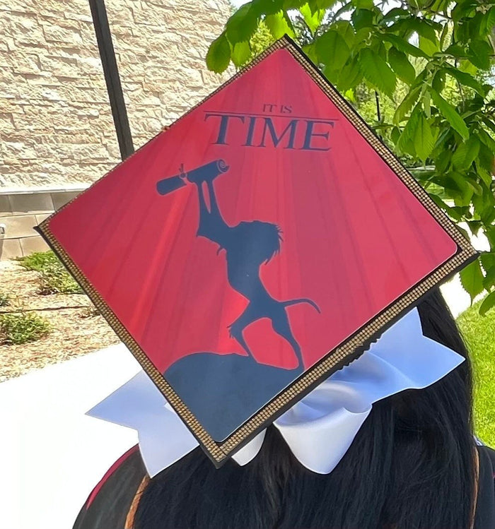 Graduate wearing Lion King It Is Time cap, back view