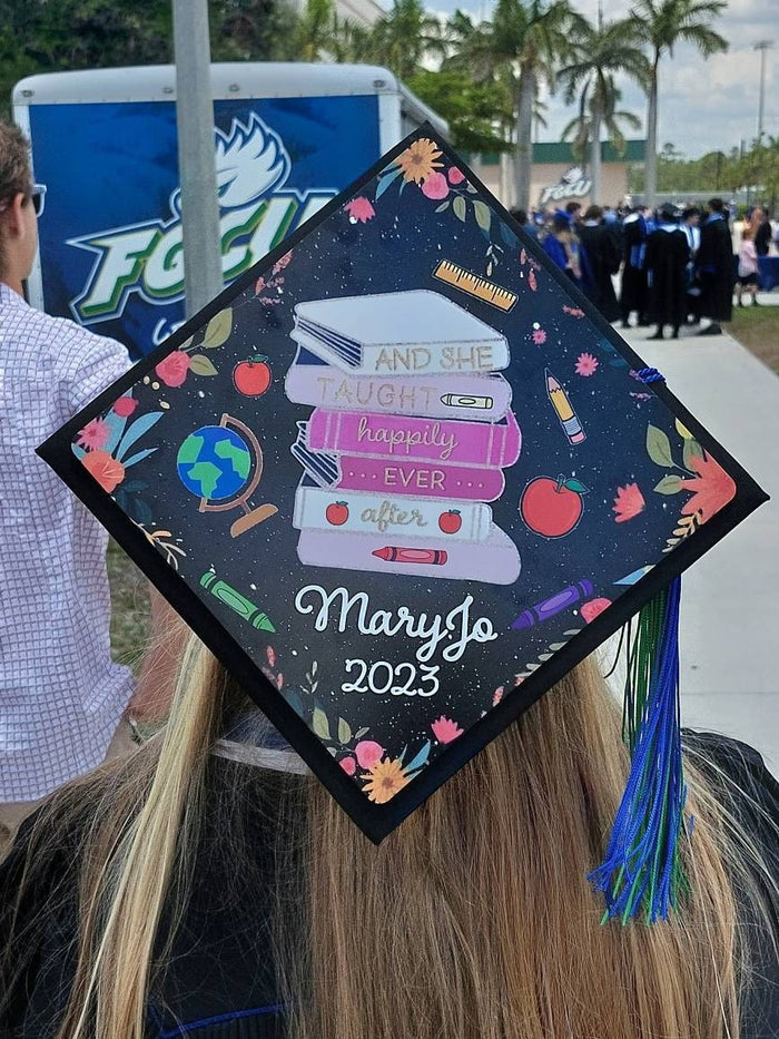 Graduate wearing teacher Happily Ever After cap at ceremony