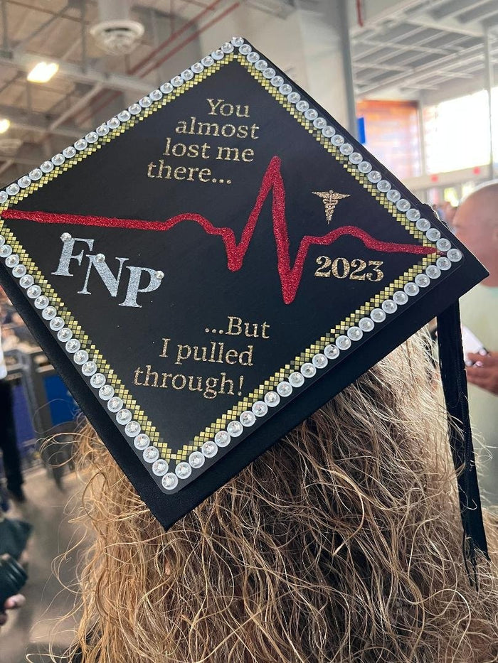 Graduate wearing FNP heartbeat cap at ceremony