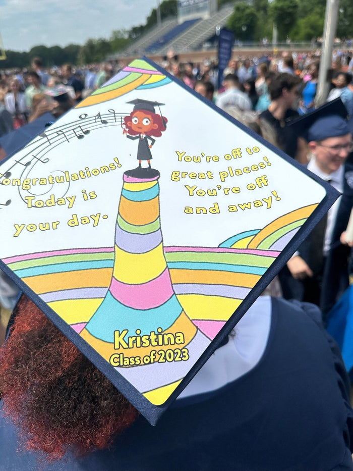 Graduate wearing Dr Seuss Off To Great Places cap in stadium