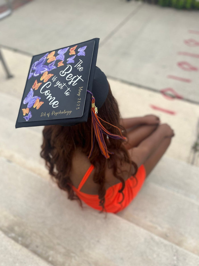 Woman wearing The Best Is Yet To Come butterfly cap on steps