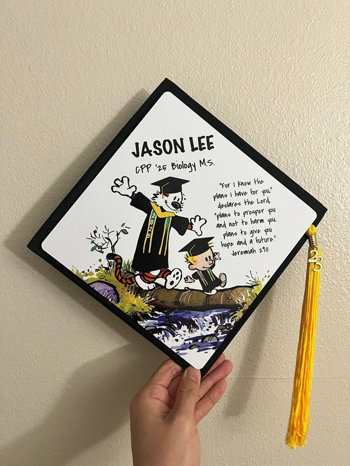 Hand holding Calvin and Hobbes Jason Lee cap