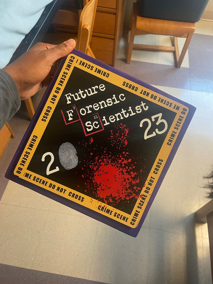 Hand holding Future Forensic Scientist 2023 topper