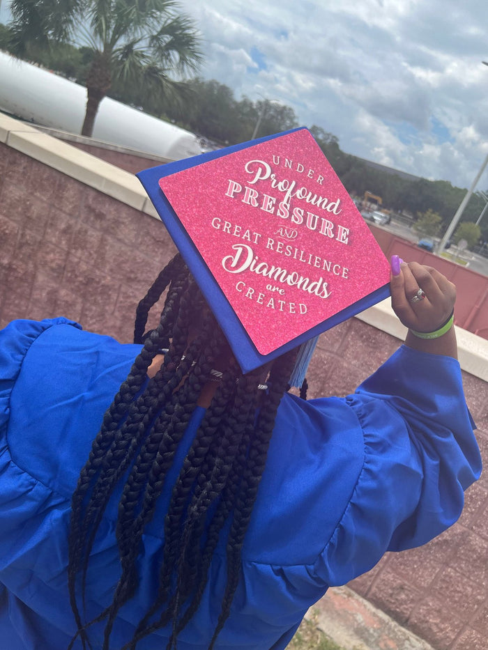 Graduate wearing pink Diamonds Under Pressure cap, back view