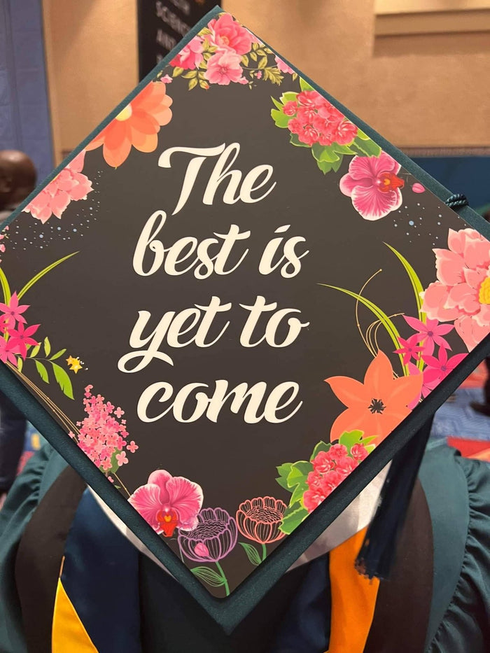 Graduate wearing The Best Is Yet To Come floral cap