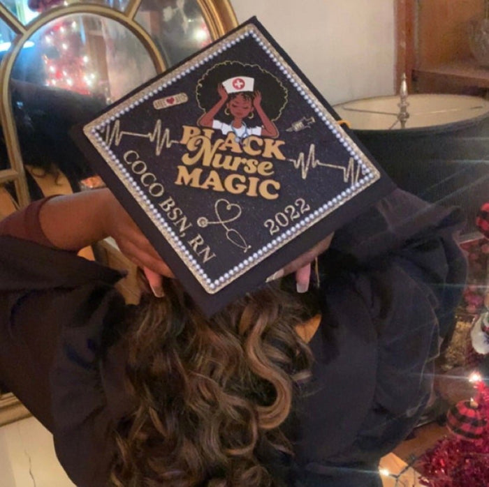 Graduate wearing Black Nurse Magic 2022 cap, back view