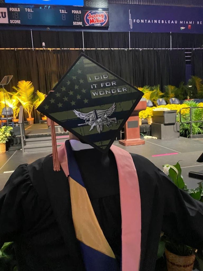Graduate wearing I Did It For Wonder military cap at arena