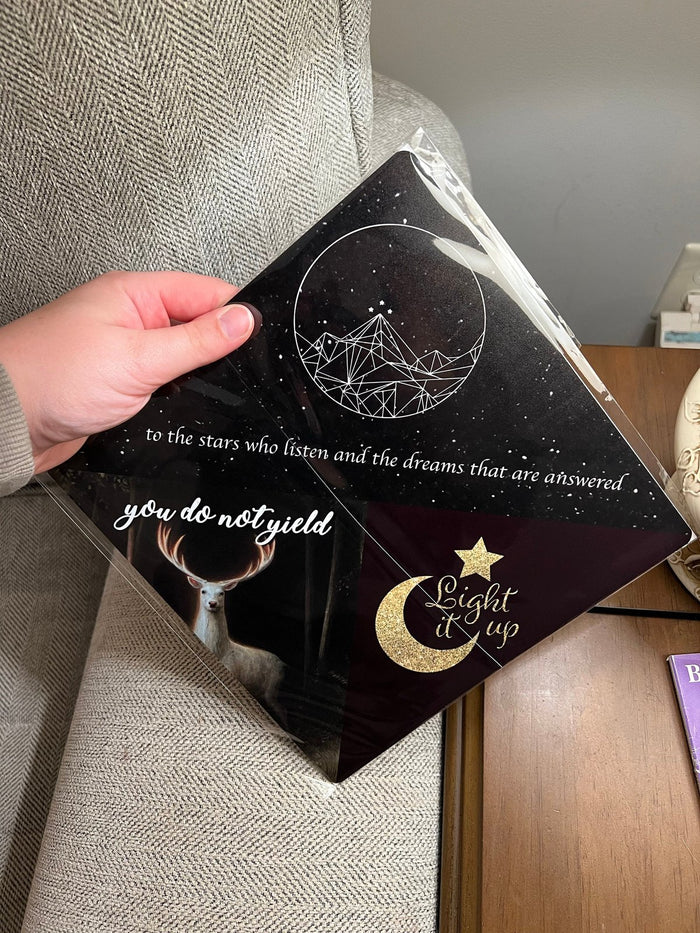 Hand holding ACOTAR You Do Not Yield topper
