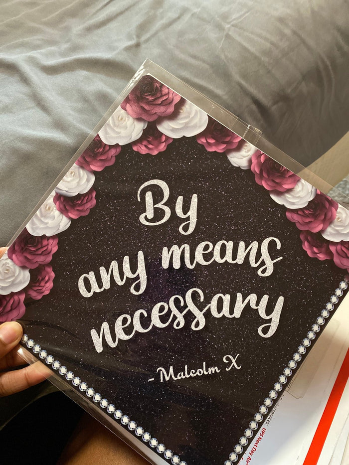 Hand holding By Any Means Necessary Malcolm X topper