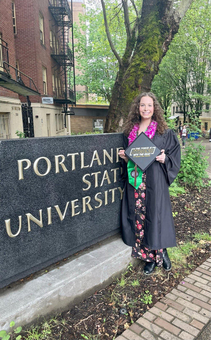Portland State graduate holding The Force Is Strong cap
