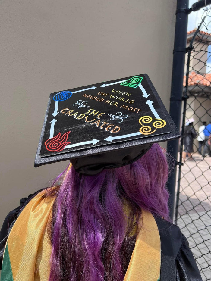 Graduate with purple hair wearing Avatar She Graduated cap