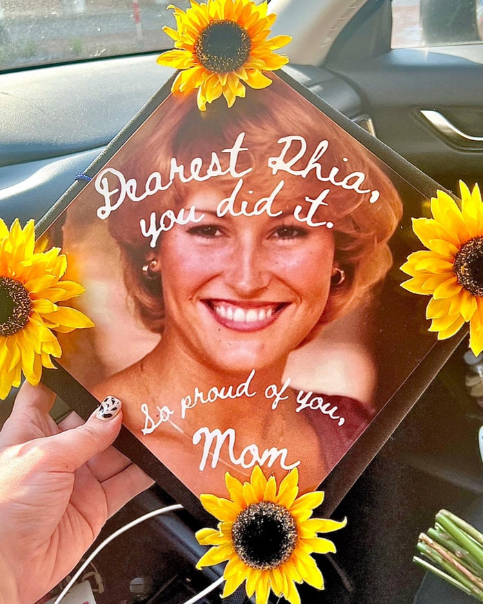 Hand holding Dearest Rhia Princess Diana sunflower cap in car