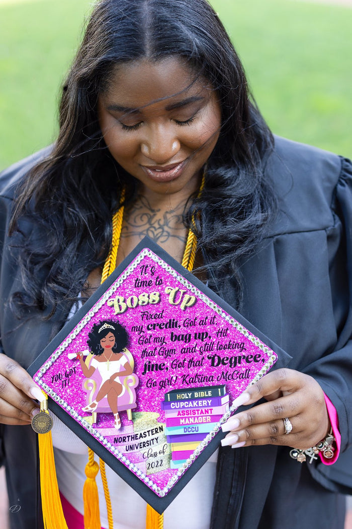 Graduate holding pink Boss Up topper