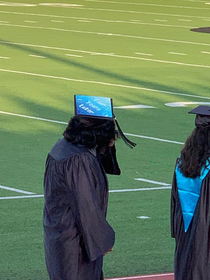 Graduate wearing SpongeBob Four Years Later cap on field