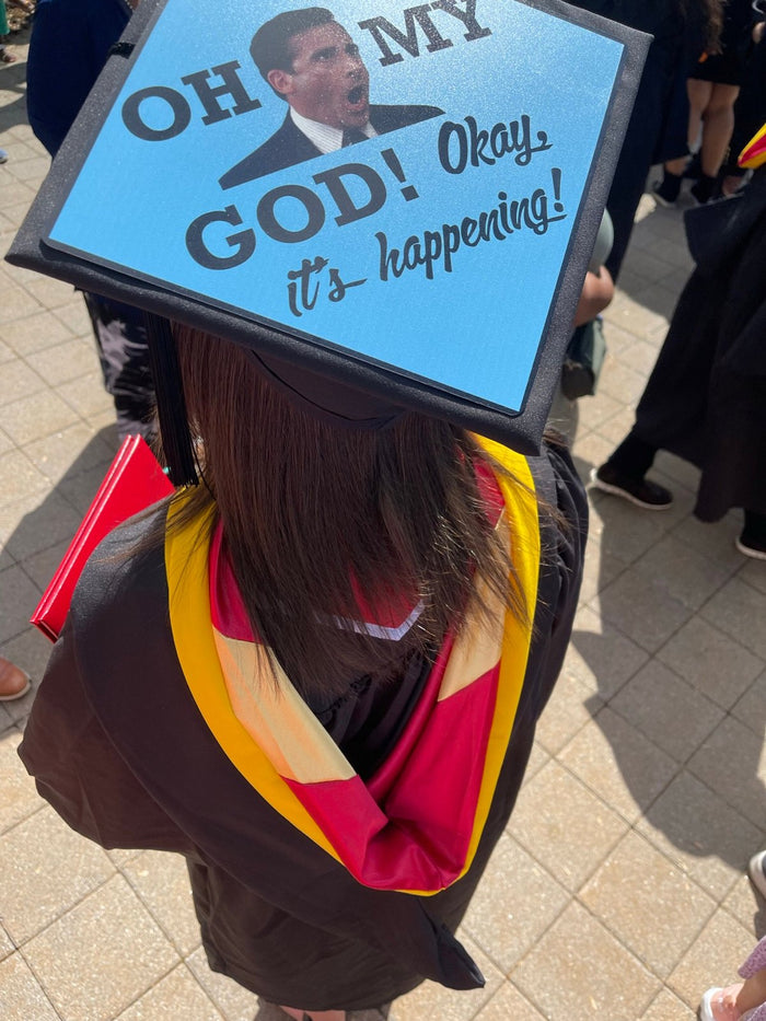 Graduate wearing Michael Scott Oh My God Its Happening cap