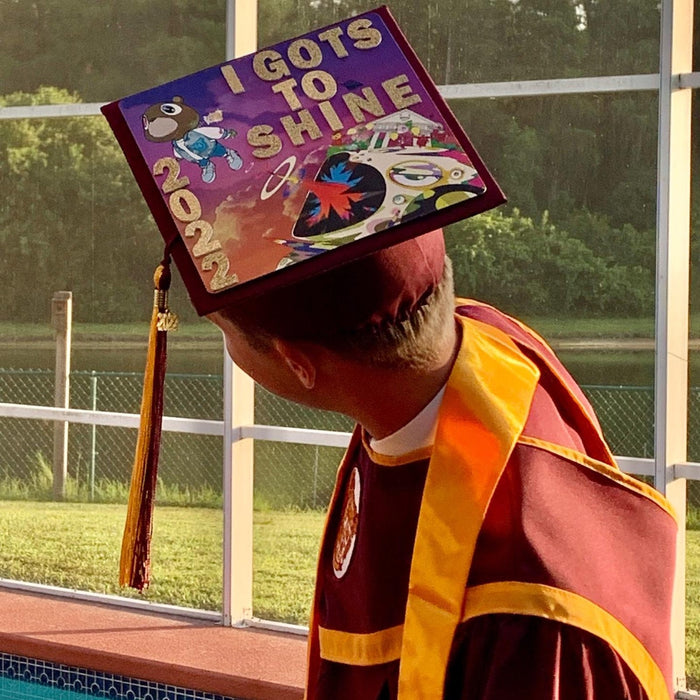 Graduate wearing Kanye I Gots To Shine cap by pool