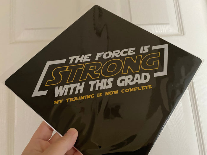 Hand holding The Force Is Strong With This Grad topper
