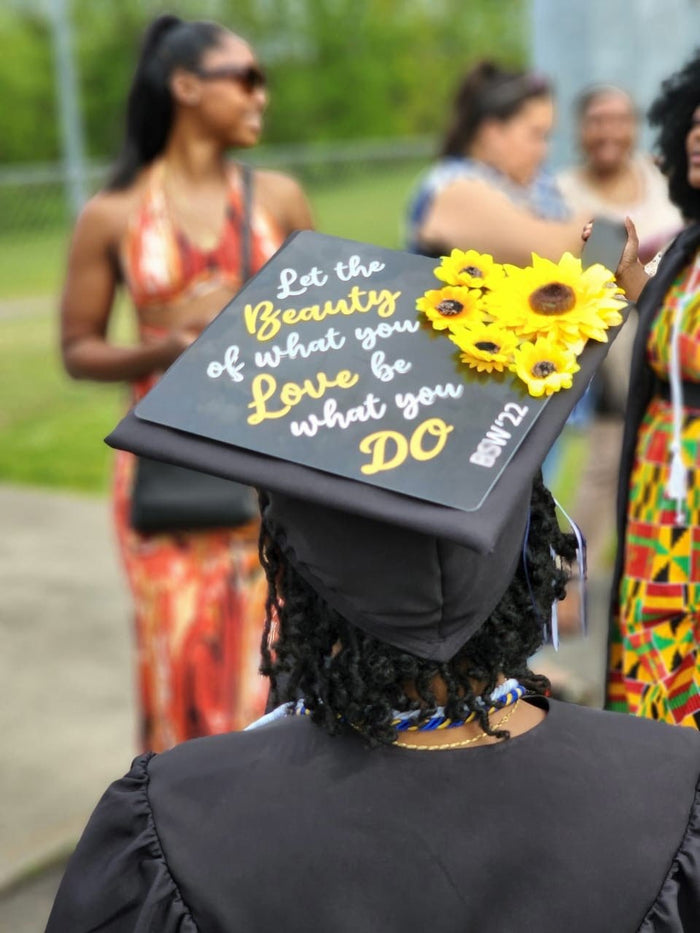 Graduate wearing Let The Beauty Of What You Love sunflower cap
