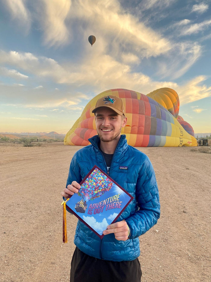 Man holding Adventure cap at balloon field