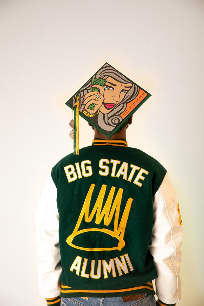 Man in alumni jacket wearing illustrated woman cap, back view
