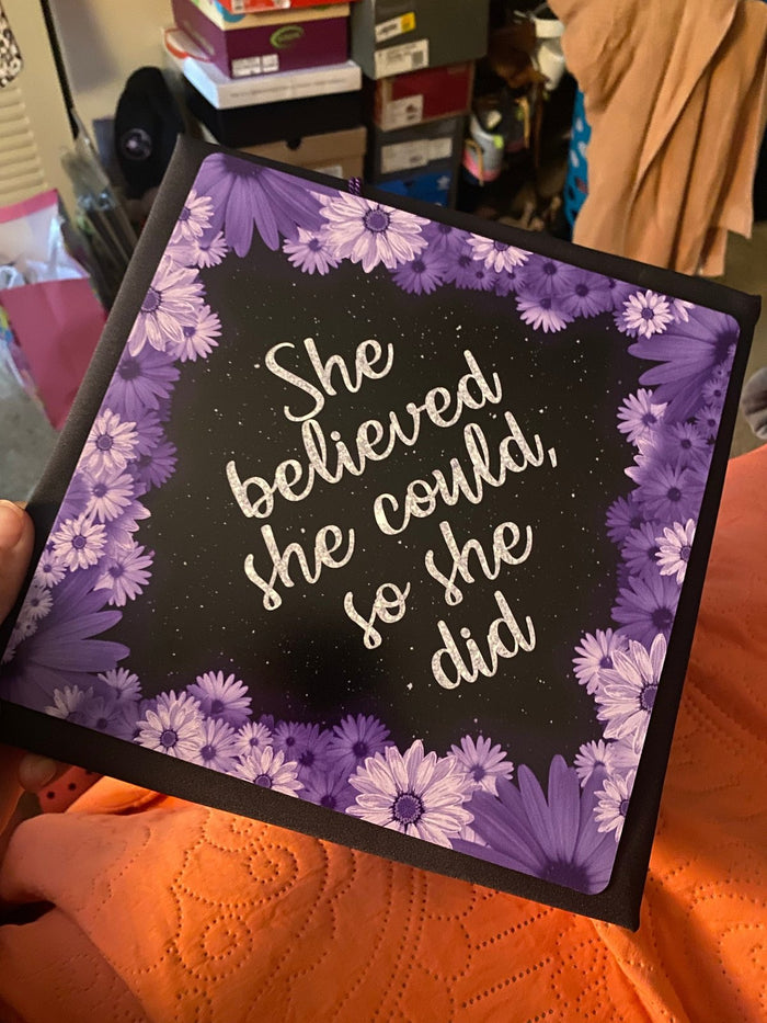 Hand holding She Believed She Could purple daisy topper
