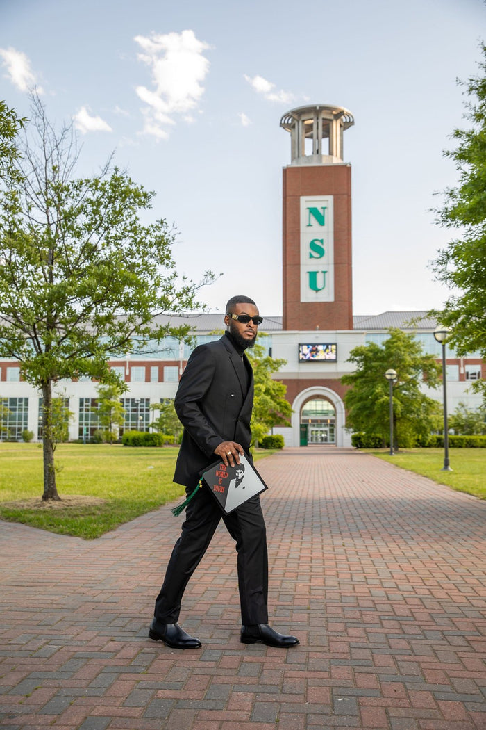 Man in suit holding Scarface cap at NSU tower