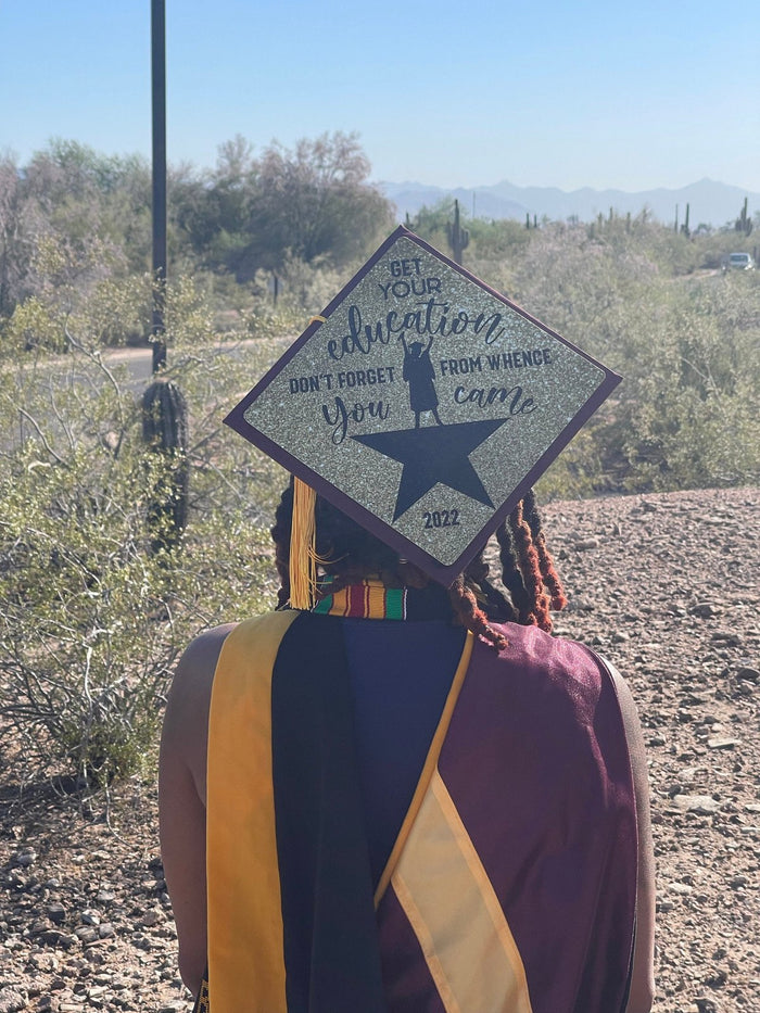 Graduate wearing Hamilton education star cap in desert