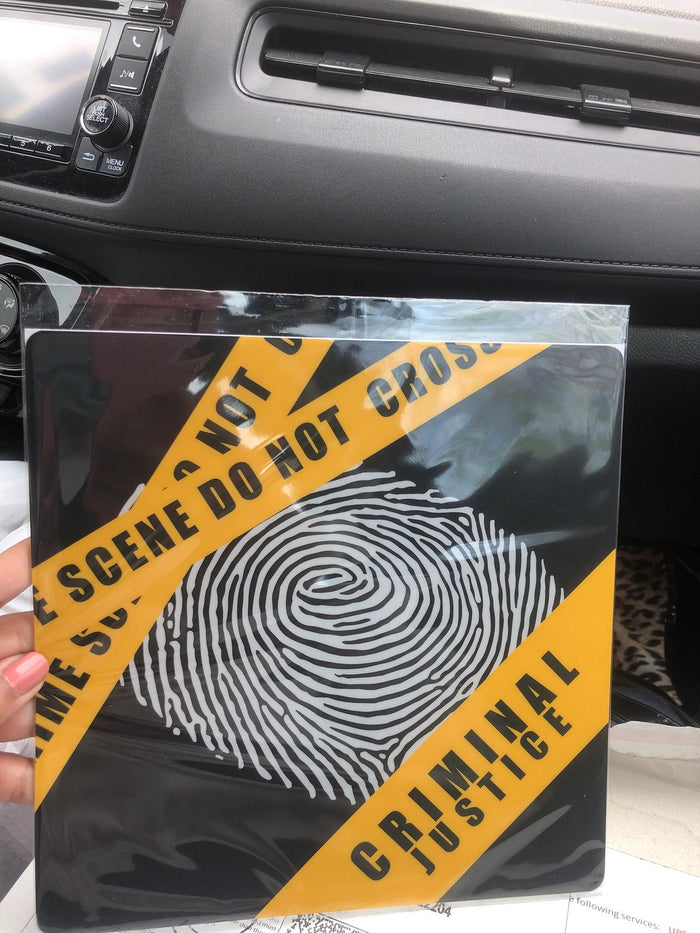 Hand holding fingerprint crime scene topper in car