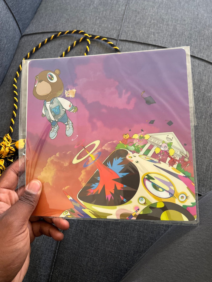 Hand holding Kanye topper in packaging