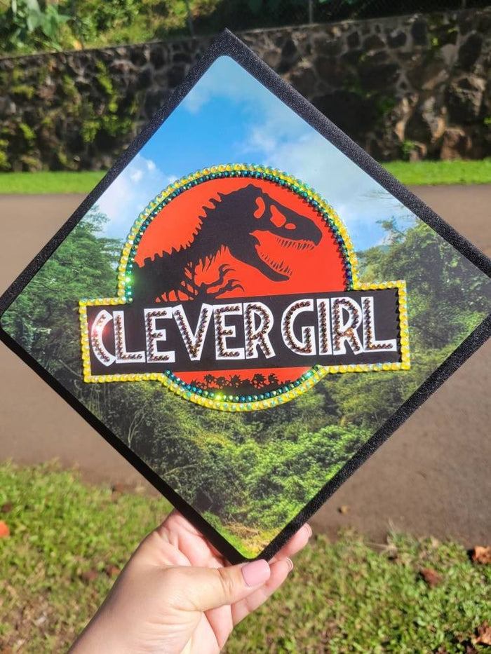 Hand holding Jurassic Park Clever Girl cap outdoors