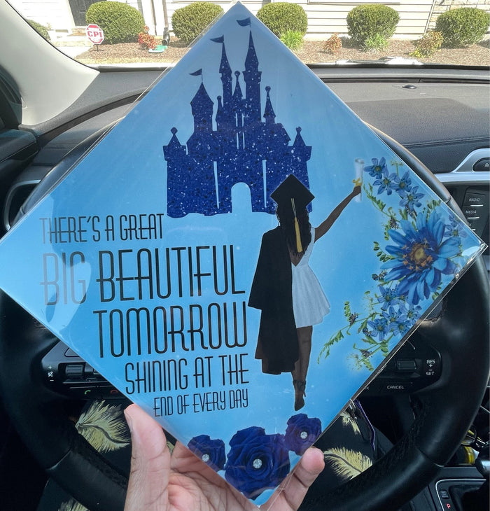 Hand holding Disney castle Big Beautiful Tomorrow cap in car