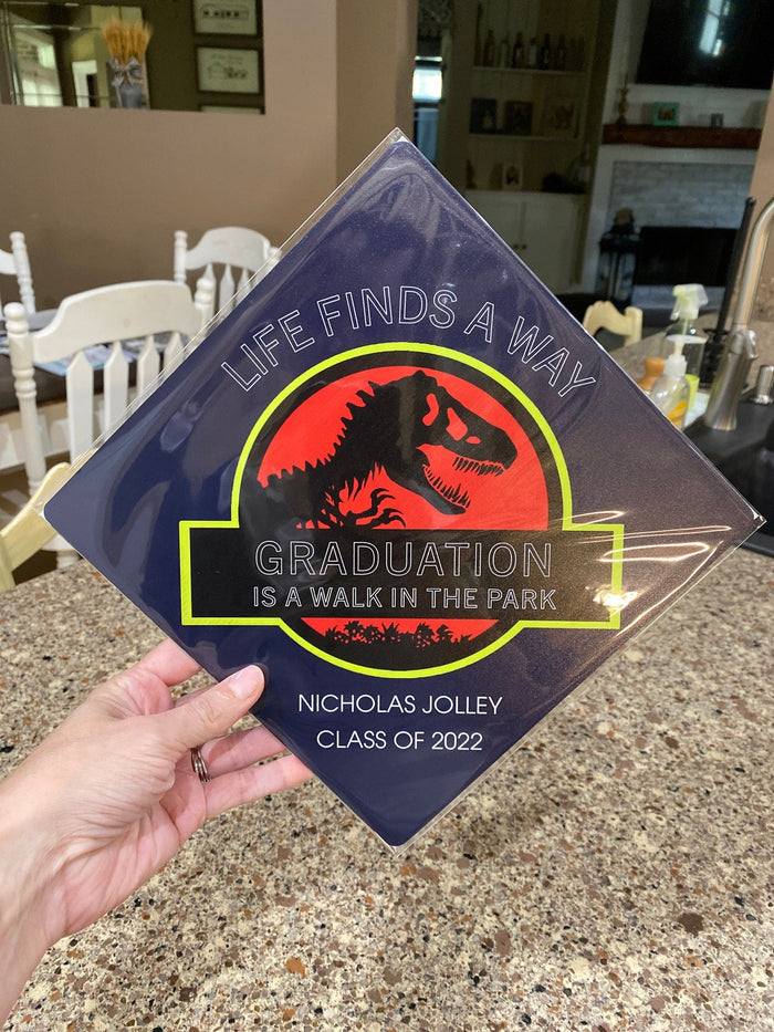 Hand holding Jurassic Park Walk In The Park topper