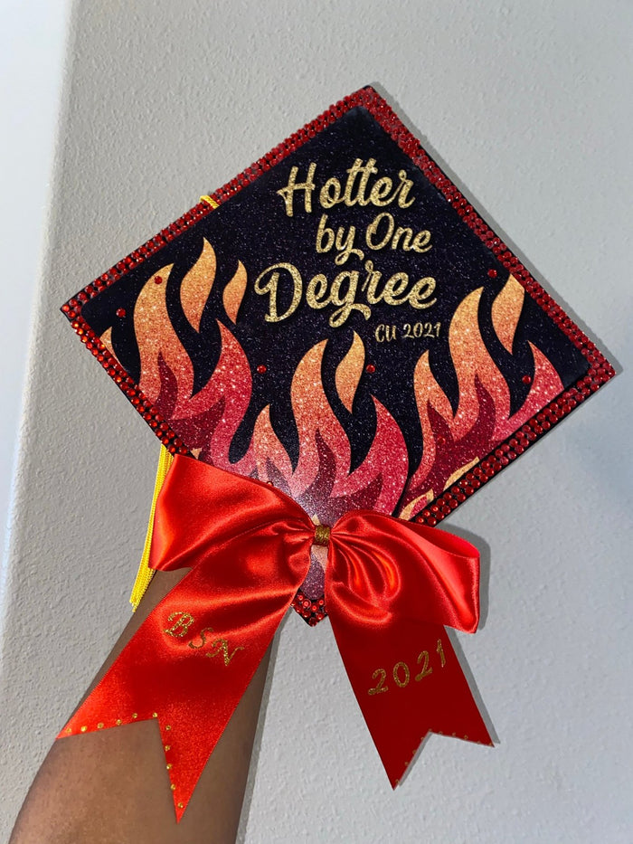 Arm holding Hotter By One Degree flame cap with red bow