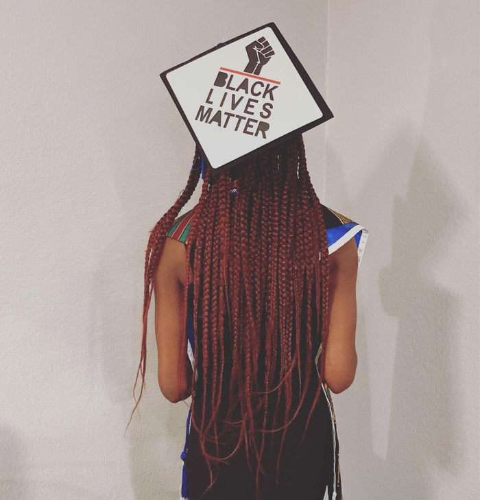 Woman wearing Black Lives Matter cap, back view