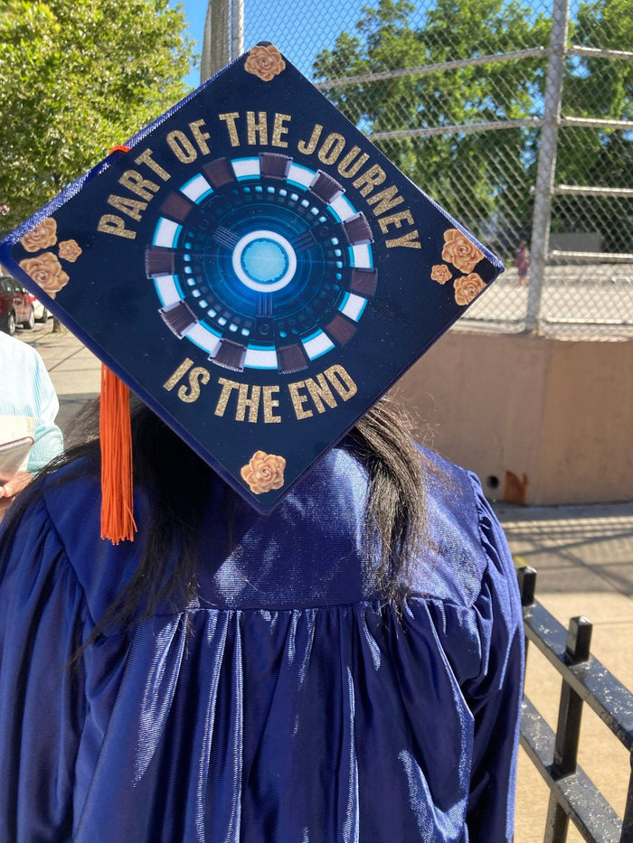 Graduate wearing Iron Man Part Of The Journey cap, back view