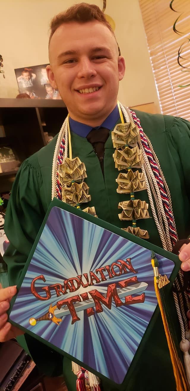 Graduate holding Adventure Time Graduation Time cap