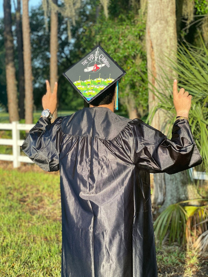 Graduate wearing Toy Story aliens Diploma cap in woods