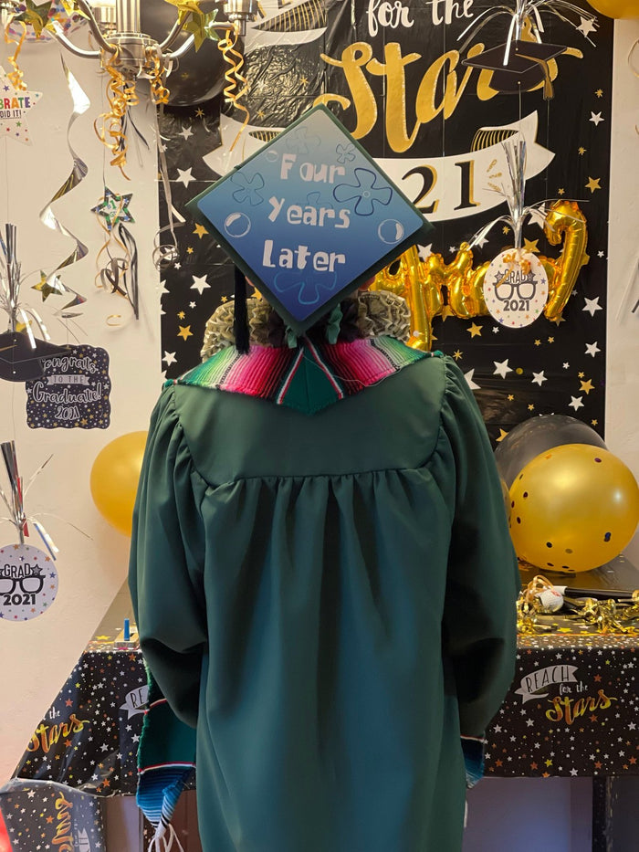 Graduate wearing SpongeBob Four Years Later cap at backdrop