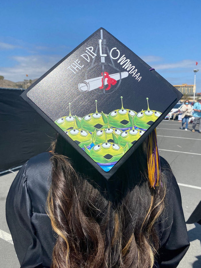 Graduate wearing Toy Story aliens cap, back view