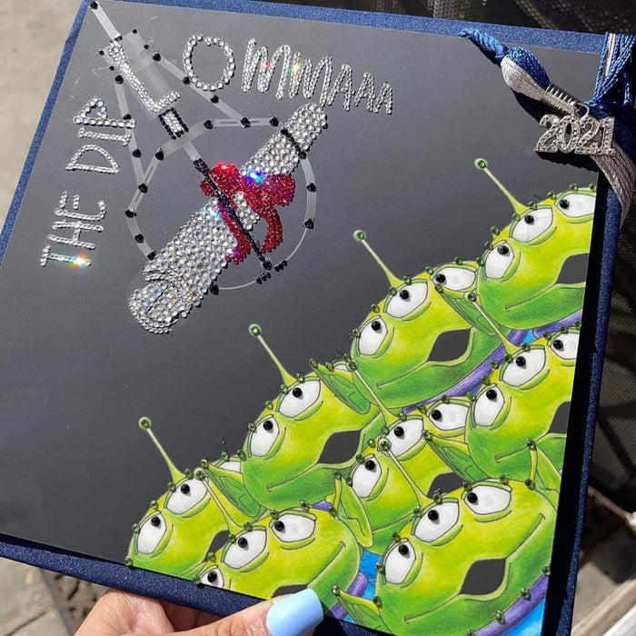 Hand holding rhinestone Toy Story aliens topper