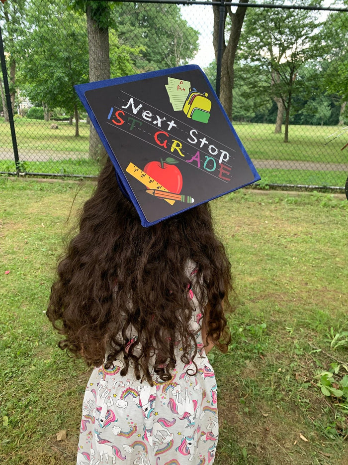 Girl wearing Next Stop 1st Grade cap in park