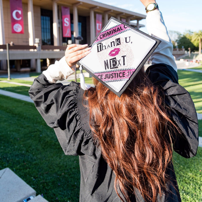 Graduate holding Thank U Next criminal justice cap over head